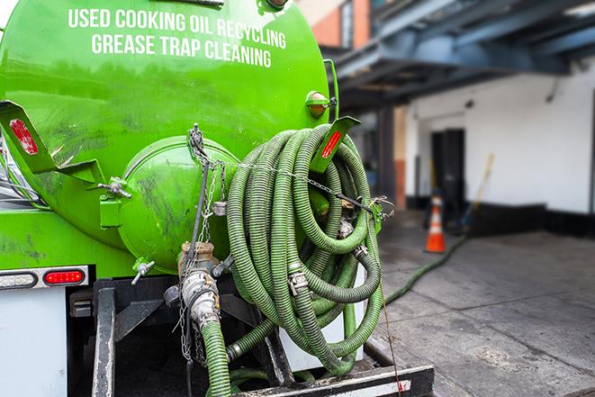 a grease trap being pumped by a sanitation technician in Skokie, IL